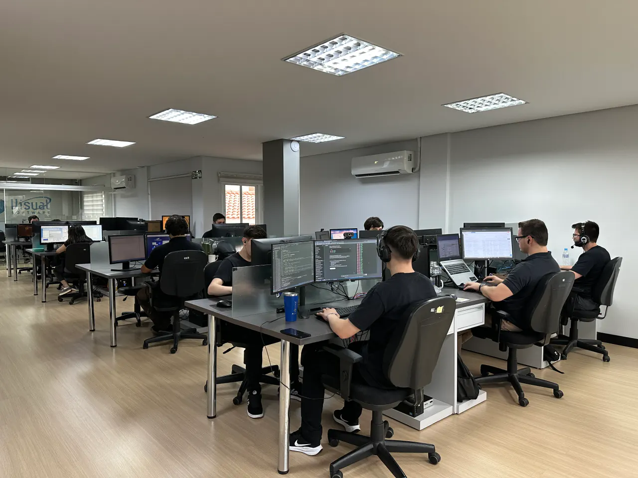 Equipe trabalhando concentrada em um escritório cheio de computadores